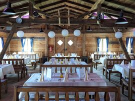 Einblick in die traditionelle Almhütte mit gedeckten Tischen aus Holz 
