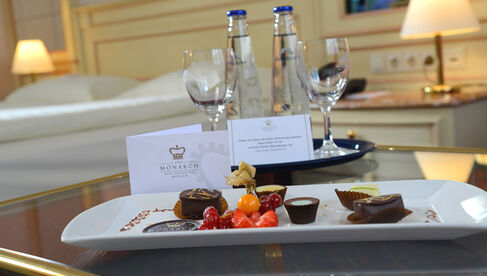 Tablett mit Pralinen und Obst neben einem Tablett mit Getränken 