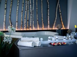 Whirlpool mit zwei Gläsern Champagner und Früchten am Beckenrand 