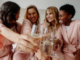 Vier Frauen stoßen mit Sekt an 