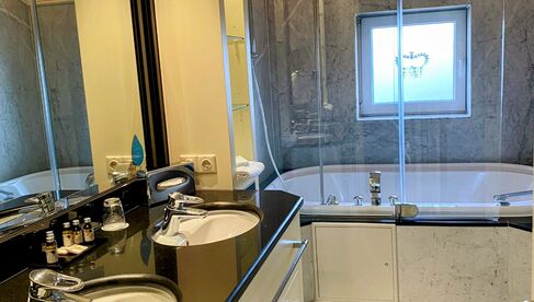 Badezimmer mit Duschbadewanne und zwei Waschbecken 