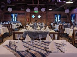 Einzelne gedeckte Tische mit karierten Tischdecken in der Almhütte 