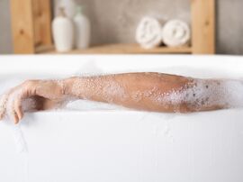 Person liegt in Badewanne mit viel Schaum 