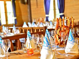 Blau-weiß gemusterte Servietten auf einem gedeckten Tisch mit frischen Brezeln 