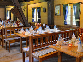 Bayrisch gedeckte Tische mit frischen Brezeln und hölzerne Sitzbänke mit karierten Kissen 