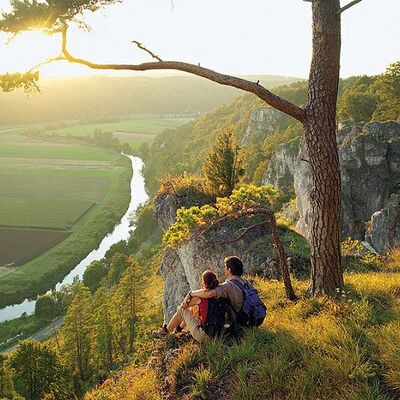 Paar sitz auf einem Berg und bestaunt die Landschaft 