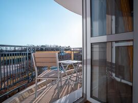 Balkon mit Tisch und Stuhl und Blick über die Landschaft 