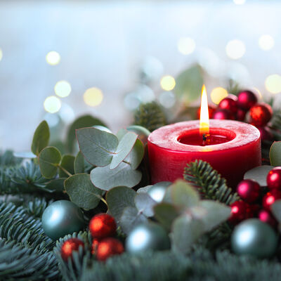 Rote Kerze in Weihnachtsgesteck